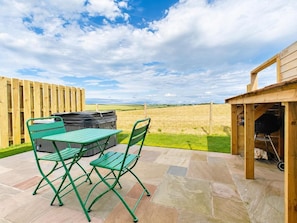 A patio with a table and chairs, a barbecue grill, and a wooden fence. - 1 Bed in Thursby (oc-b45540) (Bank End)