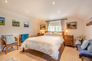 A bedroom with a large bed, two bedside tables, a chair, and artwork on the walls. - 2 Bed in Tetford (oc-g45404) (Tetford)