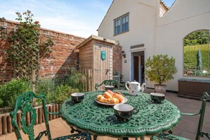 A patio with a round table, chairs, and a small garden area. - 2 Bed in Tetford (oc-g45404) (Tetford)