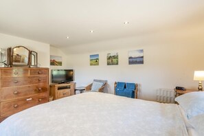 A bedroom with a large bed, a dresser, a television, and wall art. - 2 Bed in Tetford (oc-g45404) (Tetford)