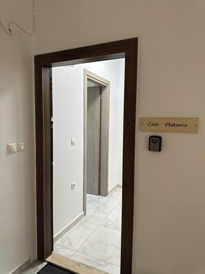 A hallway with a wooden door frame, a sign reading 'Casa Platania,' and a digital lock on the wall. - Casa Platania – Private Mountain Retreat in Rhodes (Rhodes)