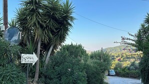 Placa de 'Casa Platania' com um caminho de cascalho que leva até um carro estacionado.