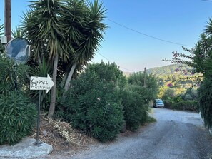 Schild für 'Casa Platania' mit einem Kiesweg, der zu einem geparkten Auto führt.