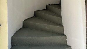 Uma escadaria leva a um patamar com uma placa que diz 'Casa Platania'.