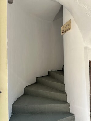 Eine Treppe führt zu einer Plattform, auf der ein Schild mit der Aufschrift 'Casa Platania' steht.
