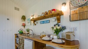 A kitchen with a wooden countertop, a kettle, a sink, and a vintage radio. - 1 Bed in Trewidland (oc-r45330) (Saint Keyne)