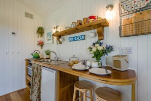 Eine Küche mit Holztischplatte, einem Wasserkocher, einer Spüle und einem alten Radio.