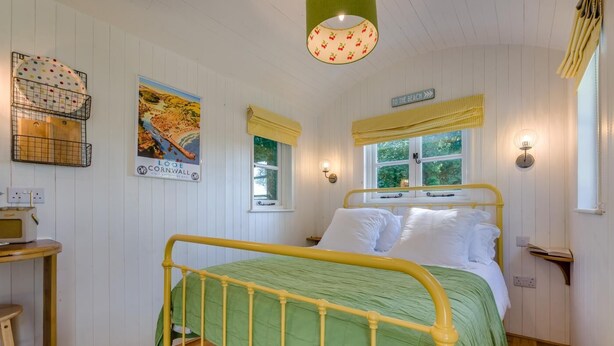 A room with a bed, a table, a lamp, a poster, and a window with a view. - 1 Bed in Trewidland (oc-r45330) (Saint Keyne)