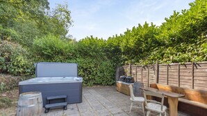 A patio with a hot tub, wooden seating, and a barbecue grill. - 5 Bed in Bishops Lydeard (oc-b45427) (Triscombe)