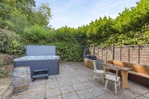 A patio with a hot tub, wooden seating, and a barbecue grill. - 5 Bed in Bishops Lydeard (oc-b45427) (Triscombe)