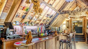 A rustic bar area with wooden beams, a cash register, and various bottles. - 5 Bed in Bishops Lydeard (oc-b45427) (Triscombe)