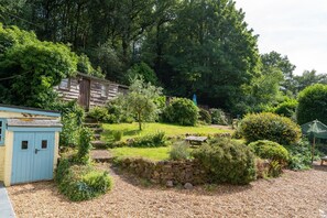 A garden with a stone wall, a shed, and a variety of plants and trees. - 5 Bed in Bishops Lydeard (oc-b45427) (Triscombe)