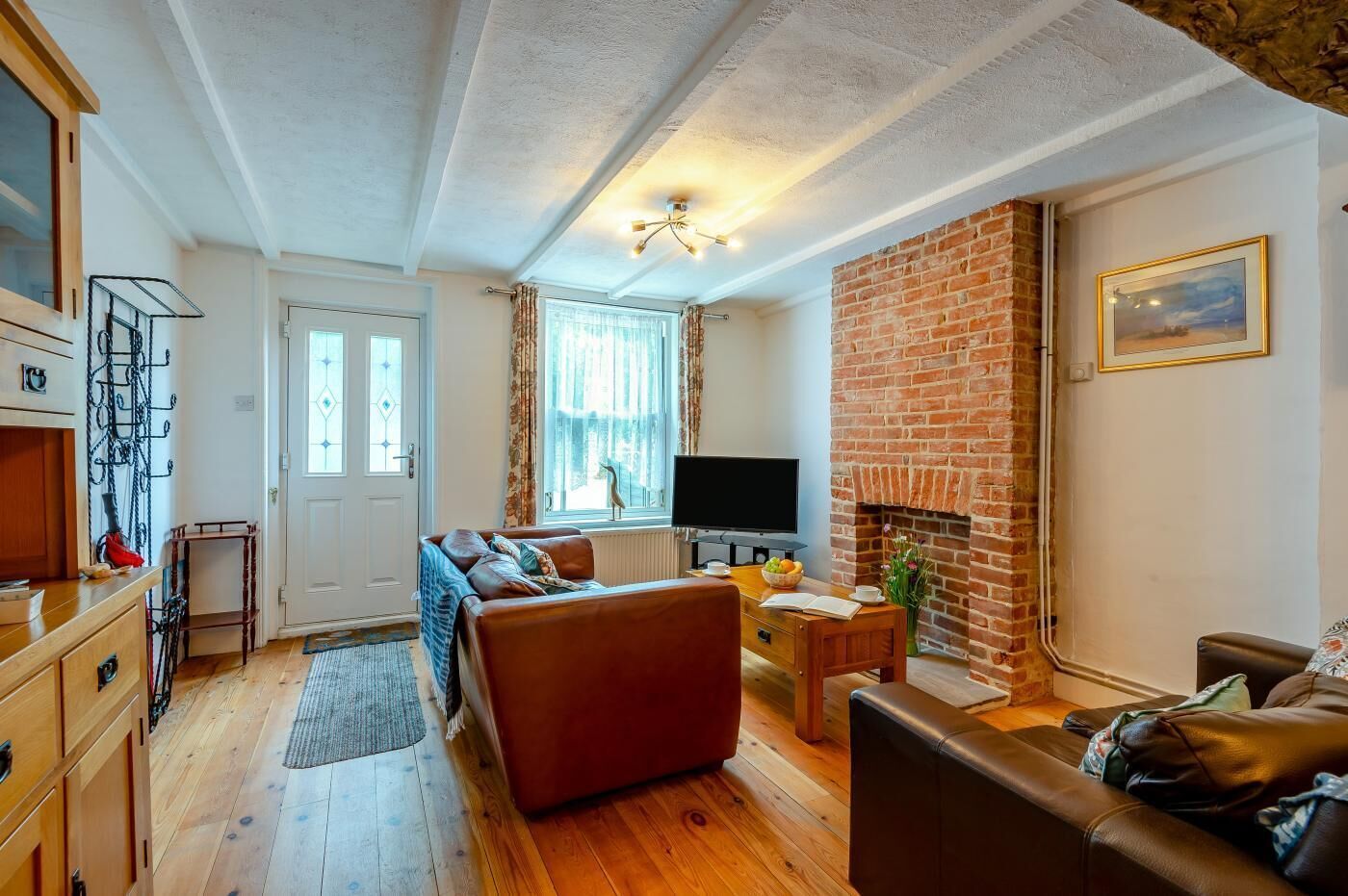 Ein gemütliches Wohnzimmer mit Kamin, Fernseher und einer bequemen Couch.