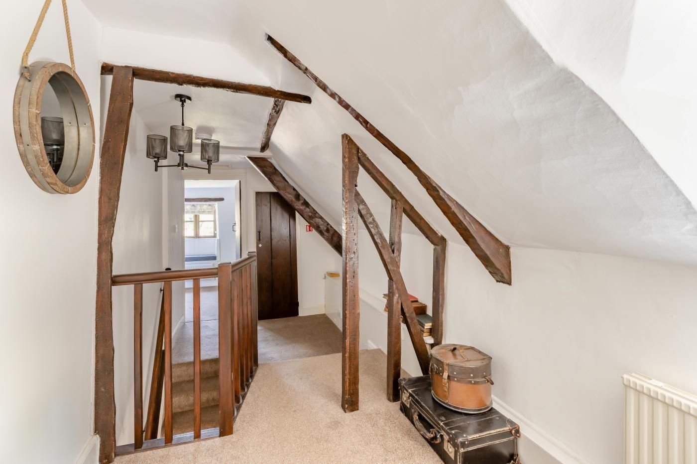 A staircase with exposed wooden beams and a rustic aesthetic, leading to an upper floor.