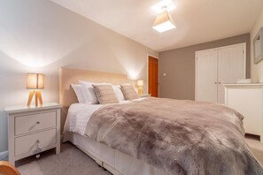 A bedroom with a bed, bedside tables, a wardrobe, and a ceiling light fixture. - 2 Bed in Ambleside (oc-lr114) (Chapel Stile)