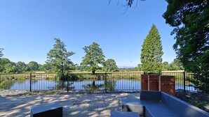 A patio with outdoor furniture, a brick wall, and a view of a lake. - 5 Bed in Llandderfel (oc-b45562) (Llandderfel)