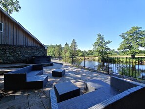 An outdoor patio with seating and a stone wall.