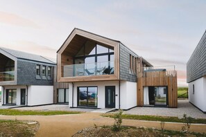 A modern two-story residential building with a balcony, large windows, and a flat roof. - 3 Bed in Mawgan Porth (oc-b599246) (Saint Eval)