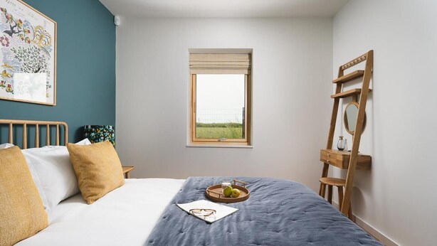 A bedroom with a bed, a window, a ladder, and a framed picture on the wall. - 3 Bed in Mawgan Porth (oc-b599246) (Saint Eval)