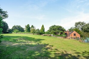 A rural property with a large grassy field, a brick house, and a wooden fence. - 1 Bed in Bournheath (oc-h45428) (Catshill)