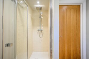 A bathroom with a glass shower enclosure, a wooden door, and a white toilet. - 1 Bed in Bournheath (oc-h45428) (Catshill)