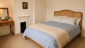 A bedroom with a bed, a dresser, a mirror, a fireplace, and a wardrobe. - 3 Bed in Giggleswick (oc-c45451) (Settle)