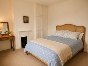 A bedroom with a bed, a dresser, a mirror, a fireplace, and a wardrobe. - 3 Bed in Giggleswick (oc-c45451) (Settle)