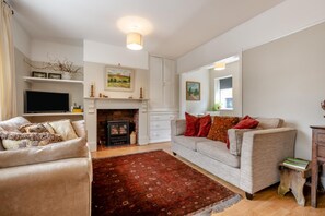 Ein Wohnzimmer mit Kamin, Sofa und Fernseher.