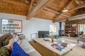 Ein gemütliches Wohnzimmer mit Kamin, Fernseher und Bücherregal.