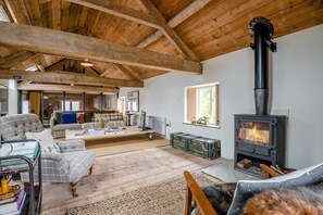 A spacious living room with a high ceiling, a fireplace, and a cozy seating area. - 1 Bed in St. Weonards (oc-t30416) (Saint Weonards)
