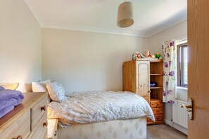 A bedroom with a bed, wooden dresser, wardrobe, and a window with curtains. - 3 Bed in Croscombe (oc-c45357) (Croscombe)