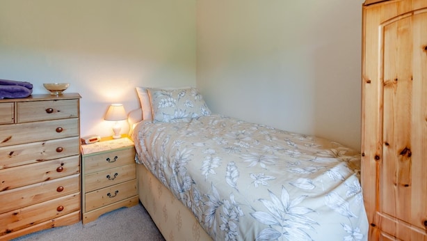 A bedroom with a bed, a dresser, a nightstand with a lamp, and a wooden wardrobe. - 3 Bed in Croscombe (oc-c45357) (Croscombe)