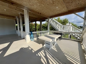 A covered outdoor area with a wooden ceiling, a white railing, and a staircase leading to an upper level. - Sound view with Private Saltwater Pool - A Tad Salty (Emerald Isle)