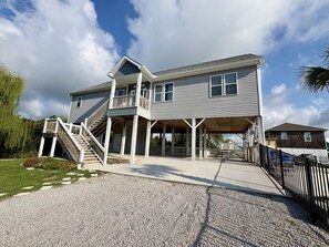 A two-story house with a covered porch, a staircase, and a driveway.