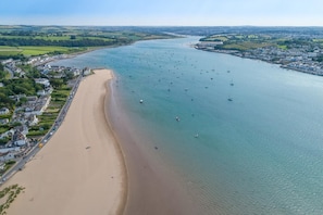 Eine Küstenstadt mit Sandstrand, Booten im Wasser und Wohngebäuden entlang der Küste.
