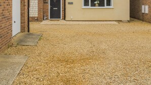 A two-story residential building with a gravel driveway and a satellite dish on the roof. - 2 Bed in Heacham (oc-l44862) (Heacham)