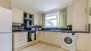 A compact kitchen with a built-in oven, microwave, and washing machine. - 2 Bed in Heacham (oc-l44862) (Heacham)
