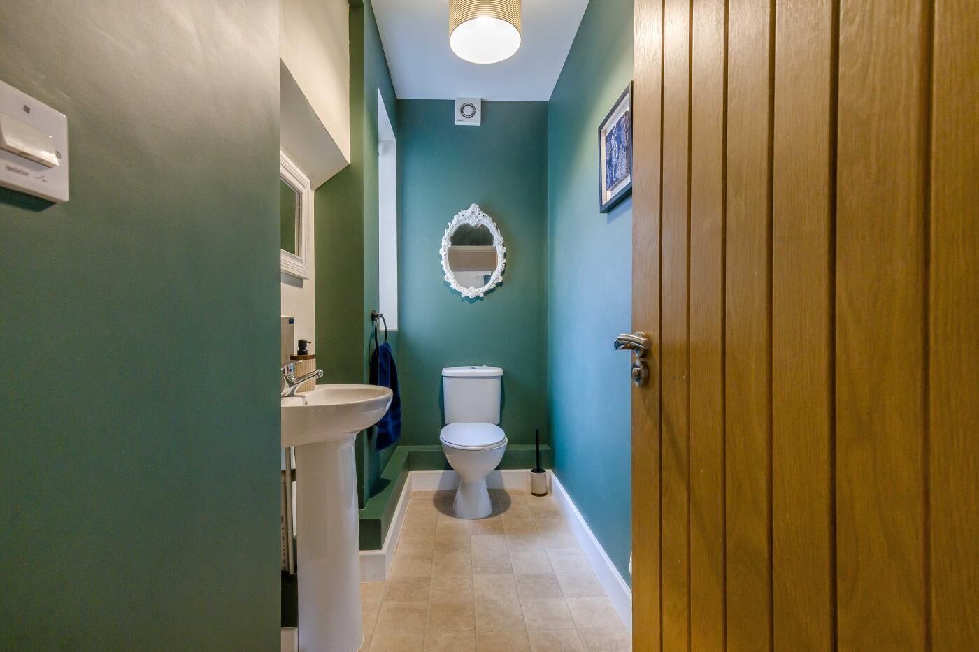 A bathroom with a sink, toilet, and a mirror.