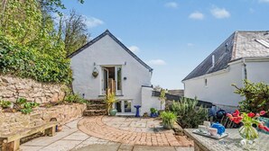 A white building with a stone wall and a paved courtyard. - 2 Bed in Marldon (oc-k41049) (Marldon)