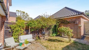 A backyard with a patio, a barbecue grill, and a brick house. - 2 Bed in Westleton (oc-w42586) (Westleton)