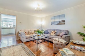 A living room with a sofa, a coffee table, a rug, and a painting on the wall. - 2 Bed in Westleton (oc-w42586) (Westleton)