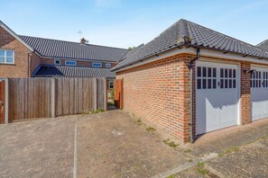 A residential property with a brick garage, a wooden fence, and a paved driveway. - 2 Bed in Westleton (oc-w42586) (Westleton)