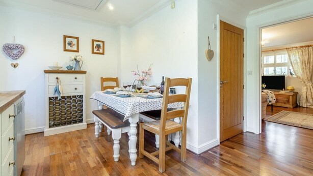 A dining area with a wooden table, chairs, and a wine rack. - 2 Bed in Westleton (oc-w42586) (Westleton)