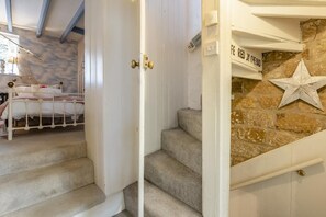 Ein Schlafzimmer mit Bett, Treppe und einer Steinwand mit Sterndekoration.