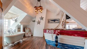 A nautical-themed room with a boat-shaped wall, a bathtub, and a star decoration. - 3 Bed in Robin Hoods Bay, Whitby (oc-g43284) (Robin Hood's Bay)