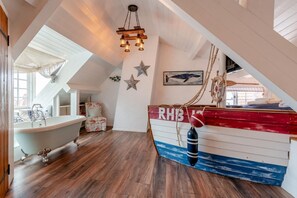 Ein raum im maritimen Stil mit einer wand in bootsform, einer Badewanne und einer Stern-Dekoration.