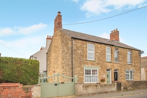 A two-story stone house with a green gate, a chimney, and a small front porch. - 3 Bed in Waddington (oc-c45566) (Waddington)