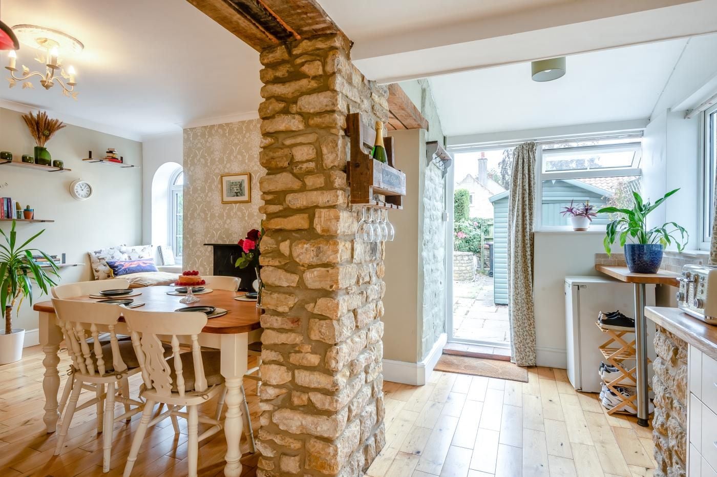 A cozy dining area with a stone pillar, wooden table, and chairs.