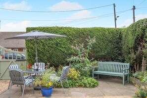 A patio with a table and chairs, a bench, and a hedge in the background. - 3 Bed in Waddington (oc-c45566) (Waddington)