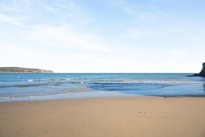 A beach with clear skies, gentle waves, and distant landforms. - 3 Bed in Abersoch (oc-a45542) (Abersoch)